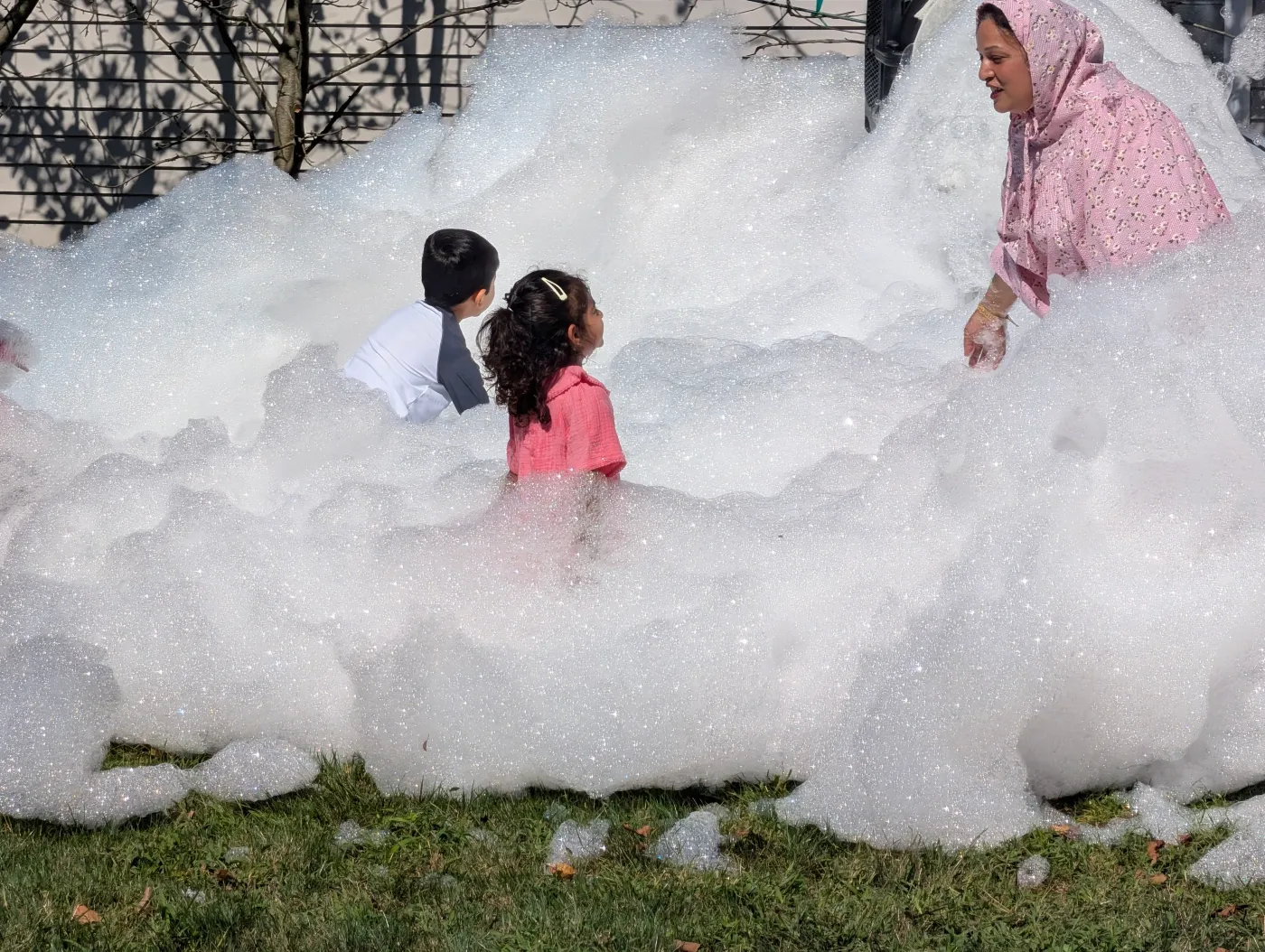 Children playing in foam on a lawn